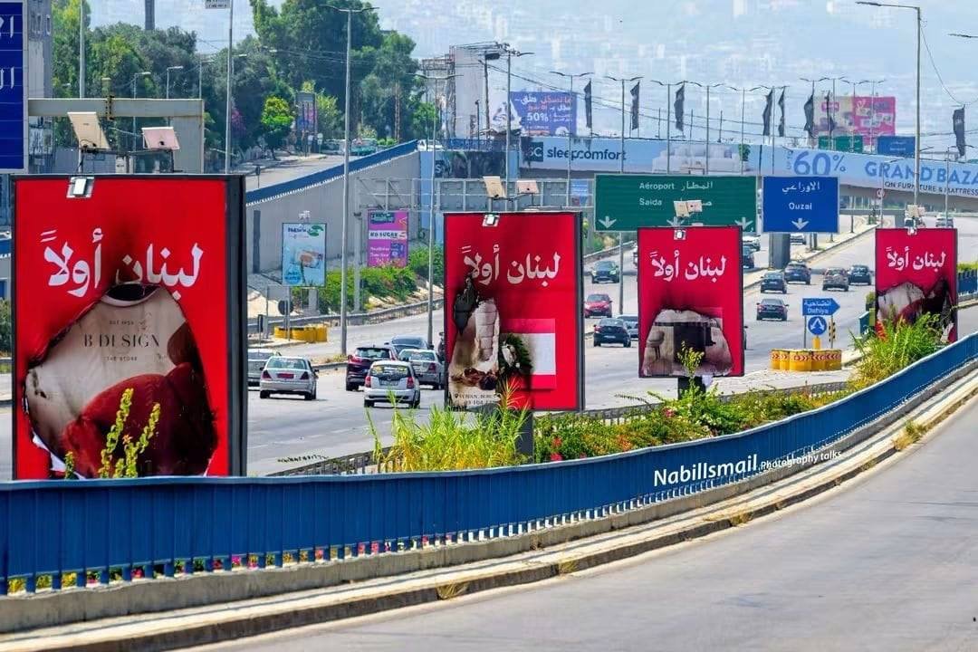 In a sarcastic social media post, Iran-backed Hezbollah is accused of burning Lebanese flags off posters in Lebanon, with another user labeling them 'Enemies of Lebanon.'