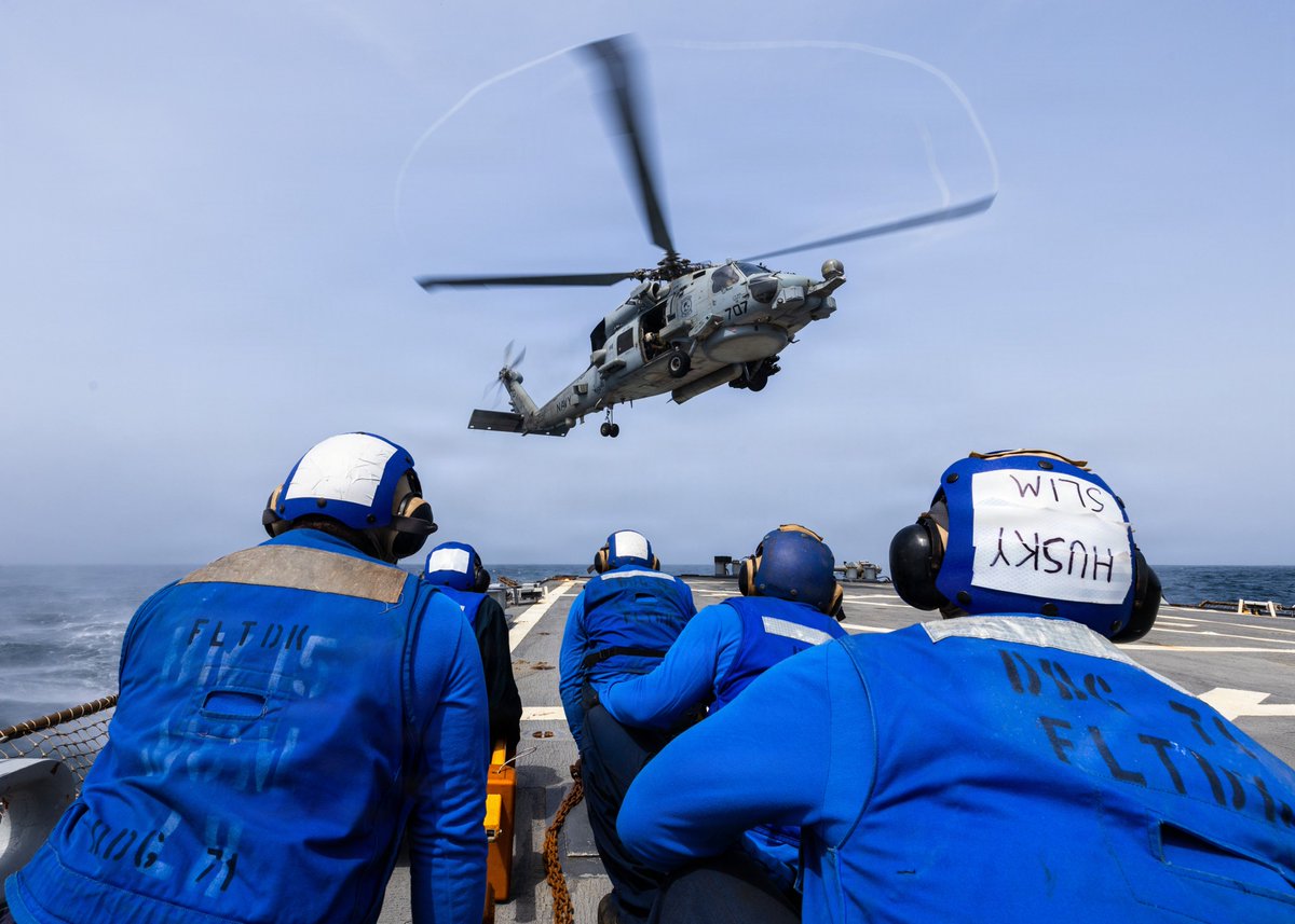 U.S. Sailors observe an MH-60R Sea Hawk landing on the flight deck aboard USS Ross (DDG 71). Ross is one of more than 20 warships supporting the U.S. blockade against Iran. As of Aug. 21, U.S. forces have redirected 68 commercial vessels, disabled 3 and boarded 3 to ensure